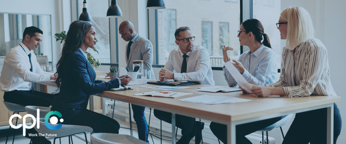 Team of Cpl professionals engaged in a discussion around a modern office table