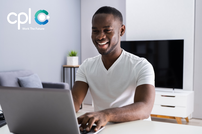 Male smiling job seeking on his laptop.