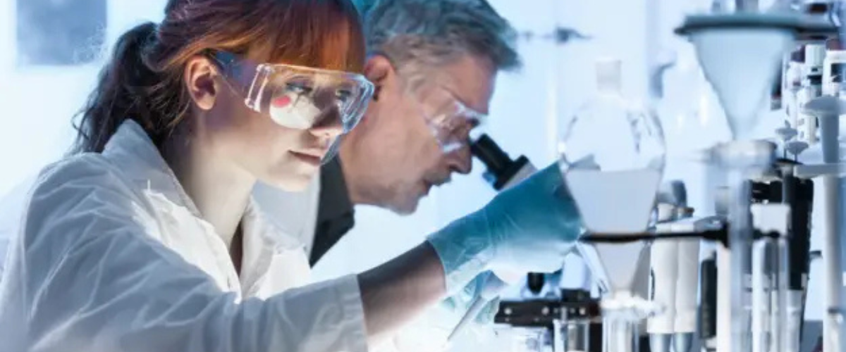 Scientists in a laboratory conducting experiments, wearing protective eyewear and gloves